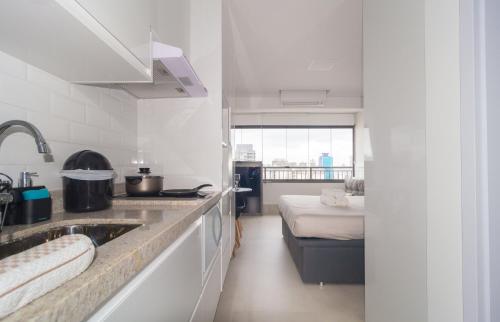 a kitchen with a sink and a bed in a room at Prime Grand Vitrali Moema in Sao Paulo