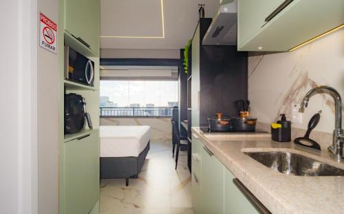 a kitchen with a sink and a bed in a room at Prime Grand Vitrali Moema in Sao Paulo