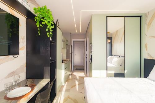 a bedroom with a white bed and a mirror at Prime Grand Vitrali Moema in Sao Paulo