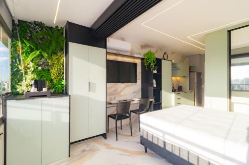 a bedroom with a bed and plants on the wall at Prime Grand Vitrali Moema in Sao Paulo