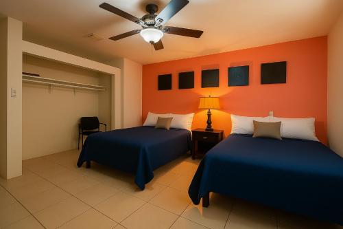 ein Schlafzimmer mit zwei Betten und einem Deckenventilator in der Unterkunft Ave Fénix Cozumel in Cozumel