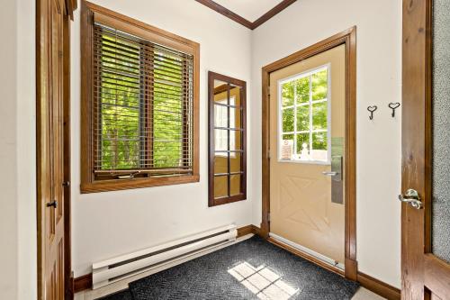 a hallway with a door and a window at Tremblant Prestige - Manoir 108-2 in Mont-Tremblant