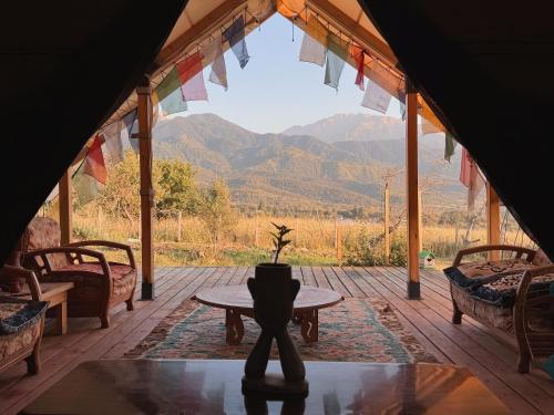 a porch with a table and a view of mountains at Family Eco Farm Getaway in Ryskulovo