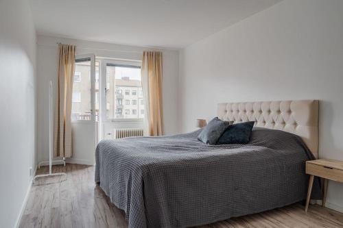 a white bedroom with a bed with two pillows on it at Central apartment Eslöv! 20 km from Lund in Eslöv