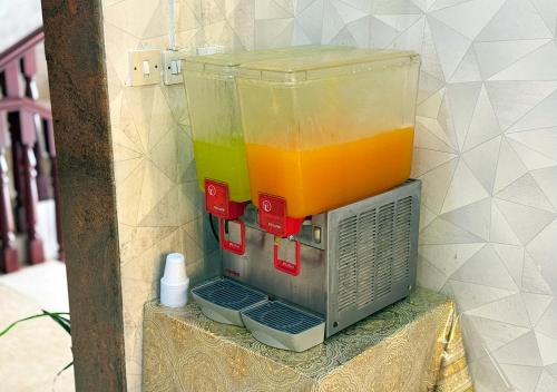 a container of orange juice sitting on top of a table at Jawharet Al Kheir Furnished Apartments in Salalah