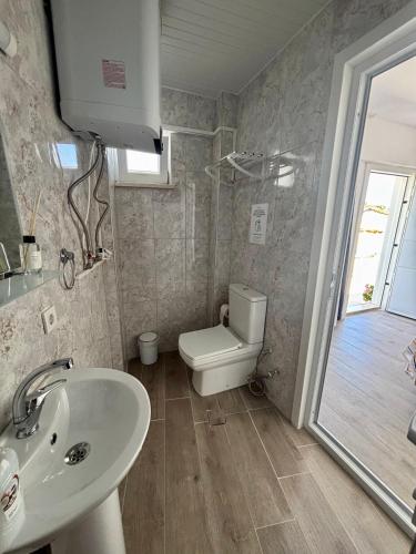 a bathroom with a sink and a toilet and a window at Huzur Pansiyon in Çanakkale