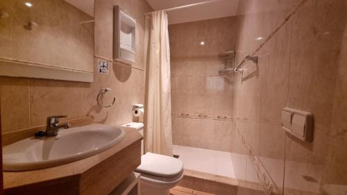 a bathroom with a sink and a shower and a toilet at Apartamento tranquilo al lado de la playa in Es Pujols