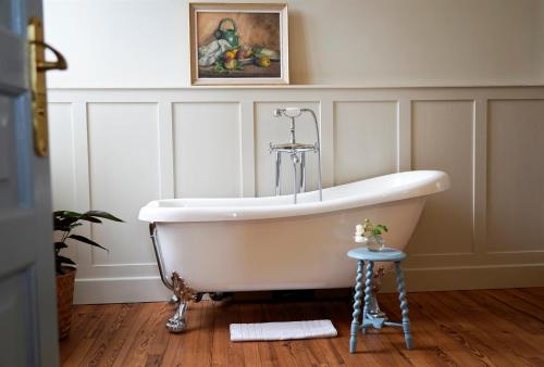 un bagno con vasca e foto appese alla parete di Chateau de Pomiro chambres d'hôtes et gîte a Montréal