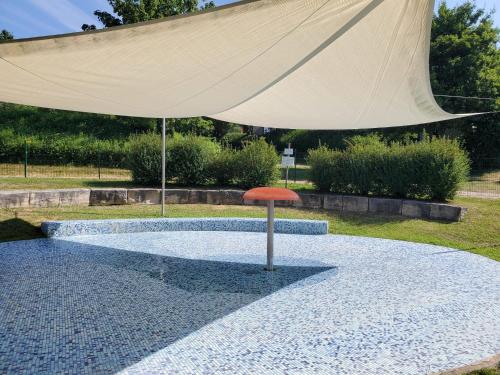 a red umbrella sitting on top of a pool of water at Tinyhaus Lieblingsplatz in Wemding