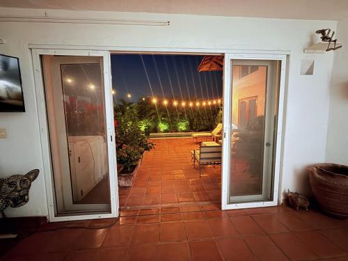 an open sliding glass door to a patio with a table at Casa Basea in Zihuatanejo