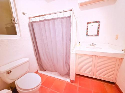 a bathroom with a toilet and a sink at Casa Basea in Zihuatanejo