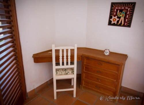 a white chair sitting next to a wooden desk at Casa Basea in Zihuatanejo