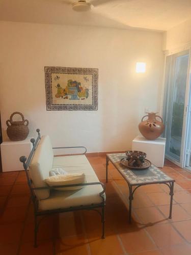 a living room with a chair and a table at Casa Basea in Zihuatanejo