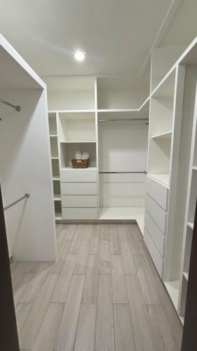a walk in closet with white cabinets and wood floors at HOTEL TRAMONTO MAZATLAN in Mazatlán
