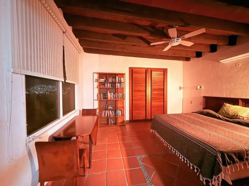 a bedroom with a bed and a ceiling fan at Casa Basea in Zihuatanejo