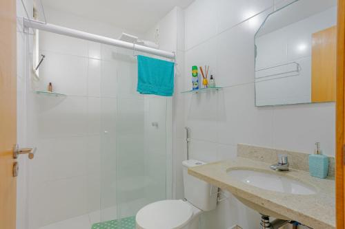 a white bathroom with a toilet and a sink at IT107 Apto Pé na Areia com com 3/4 - Itacimirim in Itacimirim