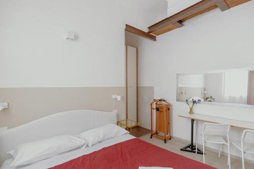 Un dormitorio blanco con una cama y un escritorio. en 24 Duomo - Camera centralissima, en Florencia