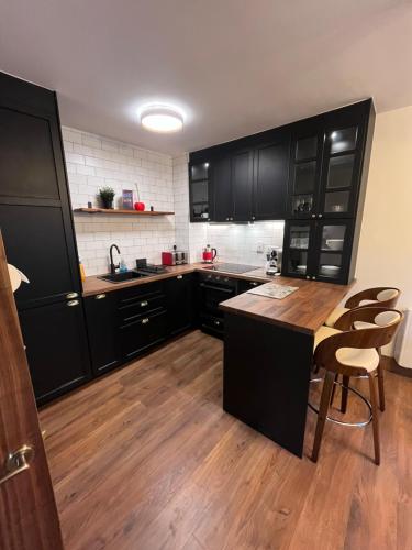 a kitchen with black cabinets and a table and chairs at 2 bedroom deluxe Galway city centre location location Free parking in Galway