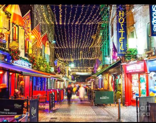 a group of people walking down a street at night at 2 bedroom deluxe Galway city centre location location Free parking in Galway