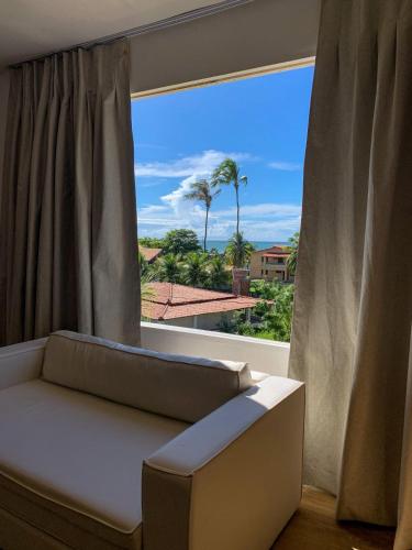 a couch in front of a window with a view at Inn Tribus Hotel in Flecheiras