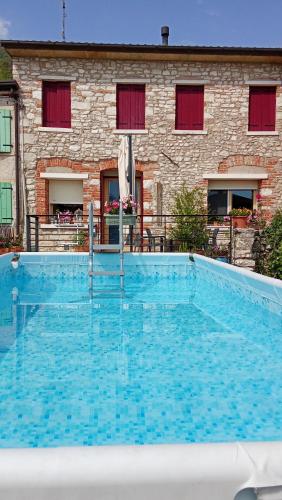 a large blue swimming pool in front of a building at Una Chicca in Valdobbiadene