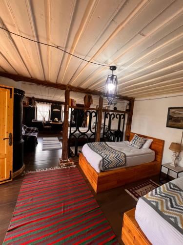a bedroom with two beds and a rug at Hnameni Bovadzor Lodge in Maksim Gorʼkiy