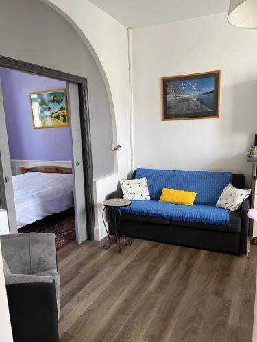 - un salon avec un canapé bleu et un lit dans l'établissement 46 Avenue Pasteur, à Saint-Malo