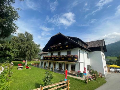 a white house with a black roof at Hotel Landhaus Lungau in Sankt Michael im Lungau