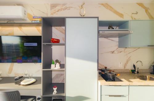 a kitchen with white cabinets and a sink at Prime Grand Vitrali Moema in Sao Paulo
