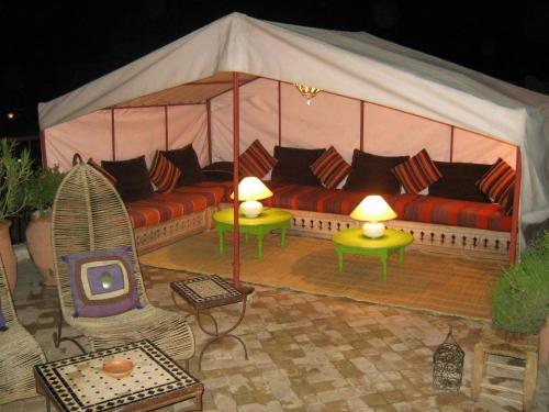 Cette tente comprend un canapé et une télévision. dans l'établissement Douarskoll, à Marrakech