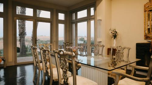 a dining room with a table and chairs and windows at Villa Soraya Lodge & Spa in Rabat