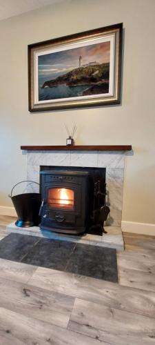a living room with a fireplace with a tv at A Classic Donegal Townhouse in Donegal
