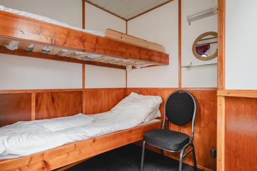 a bunk bed and a chair in a room at Lofoten Cruise & Hotel in Svolvær