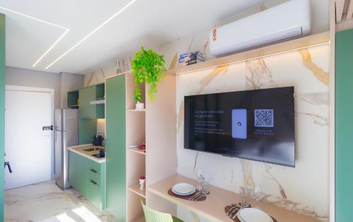 a living room with a tv on a wall at Prime Grand Vitrali Moema in Sao Paulo