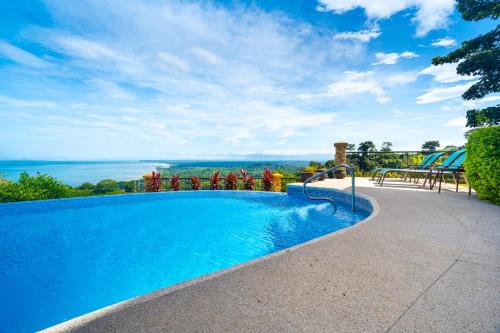 a swimming pool with a view of the ocean at 1hr Sjo Airport-ocean Views-gated Beachclub-pool in Tarcoles