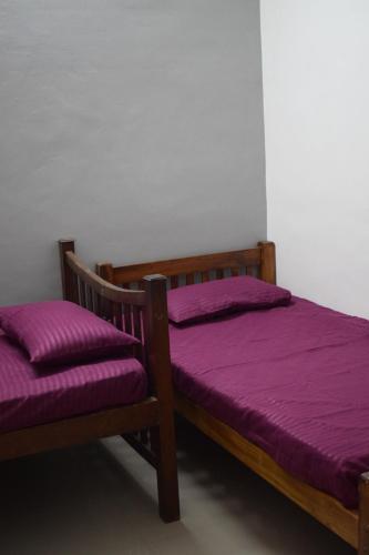 two beds in a room with purple sheets at FlexTays Campus - Budget Student Stays in Trivandrum