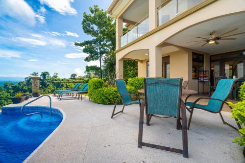 an outdoor patio with chairs and a swimming pool at 1hr Sjo Airport-ocean Views-gated Beachclub-pool in Tarcoles