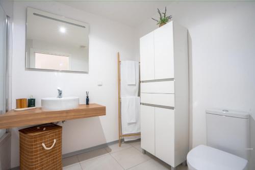 a bathroom with a sink and a toilet at Hygge Madeira by LovelyStay in Caniço