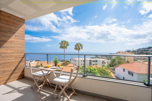 a balcony with a table and chairs and a view of the ocean at Hygge Madeira by LovelyStay in Caniço