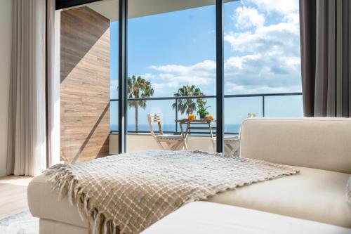 a room with a large window with a view of the ocean at Hygge Madeira by LovelyStay in Caniço