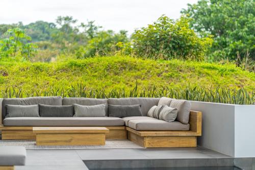 a couch sitting on a patio in front of a field at New! Modern-luxury-3 Suites-pool-ojochal-100mbps in Ojochal