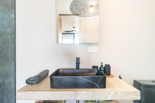 a kitchen with a black sink on a wooden counter at New! Modern-luxury-3 Suites-pool-ojochal-100mbps in Ojochal