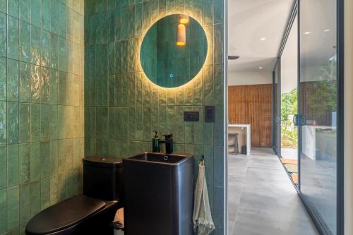 a bathroom with a sink and a toilet and a mirror at New! Modern-luxury-3 Suites-pool-ojochal-100mbps in Ojochal