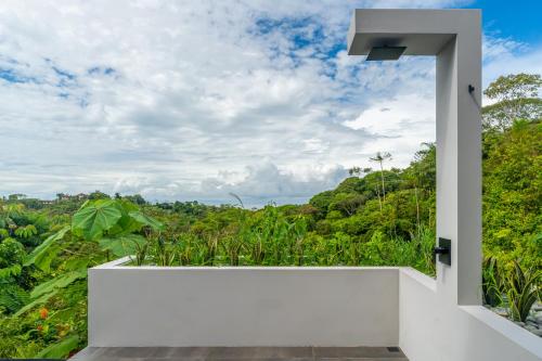 a white balcony with a view of the forest at New! Modern-luxury-3 Suites-pool-ojochal-100mbps in Ojochal