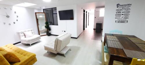 a living room with a couch and a table and chairs at Otoño Aparta Suite in Ipiales