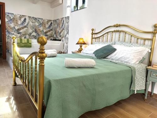 a bedroom with a bed with a green comforter at Dimora Lilly in Acireale