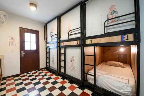 a room with two bunk beds and a checkered floor at Masaya Santa Marta in Santa Marta