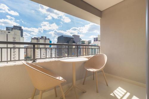 a balcony with a table and chairs and a view at Prime Grand Vitrali Moema in Sao Paulo