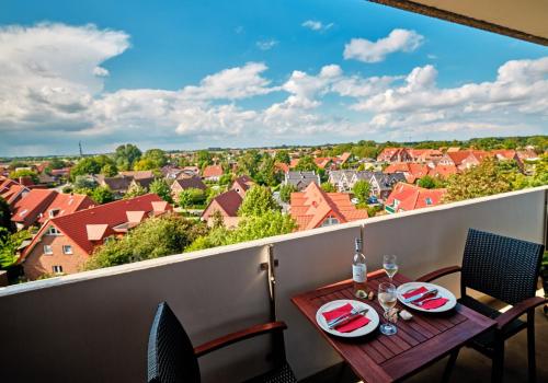 a table on a balcony with a view of the city at "FW Sonnenschein mit Pool, Balkon, Fahrrad und WLAN" in Wangerland