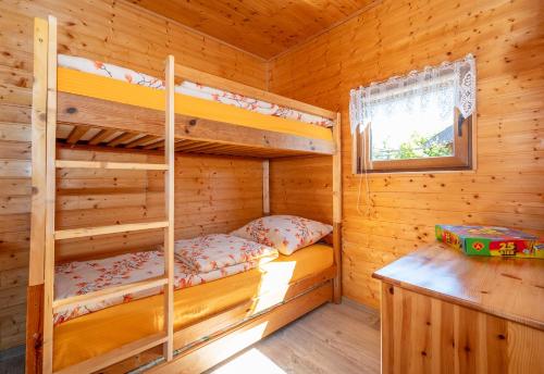 a bedroom with bunk beds in a log cabin at ZŁOTY OGRÓD in Darłowo
